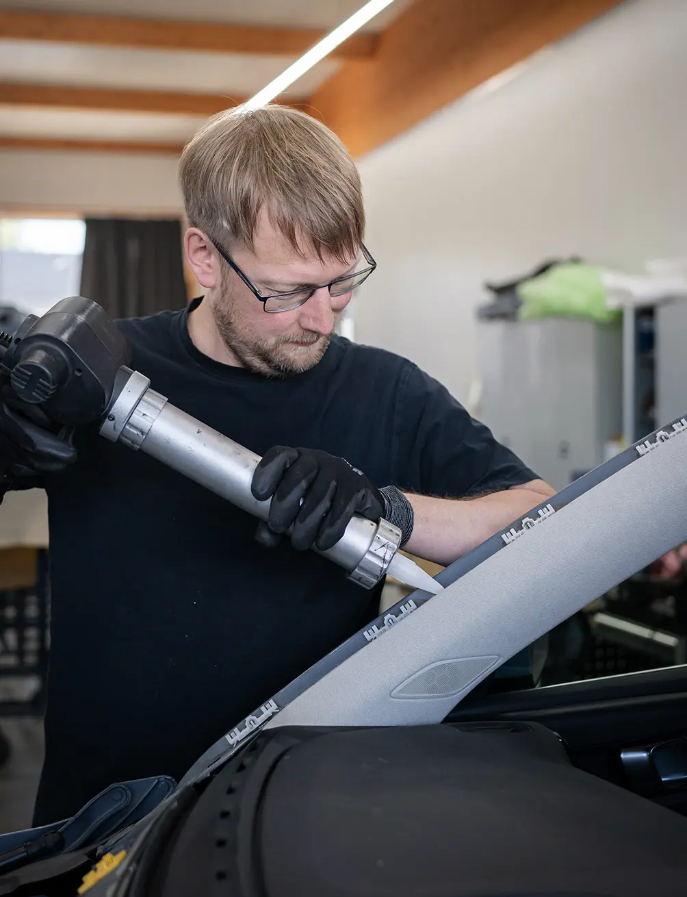Mitarbeiter mit einem Auto in der Werkstatt